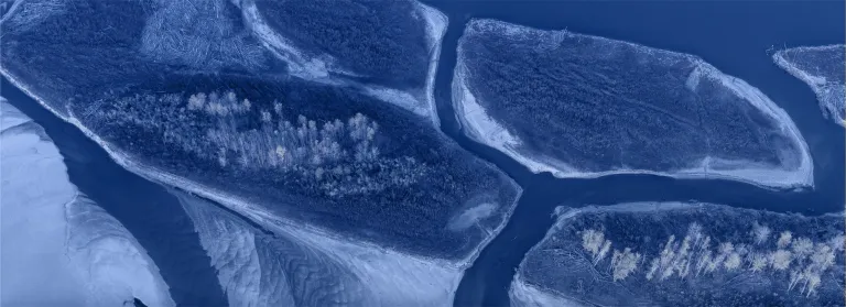 Blue washed image of river split through wild lands